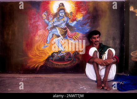 A man sitting near the mural of Lord shiva in Wadakancherry Siva Temple, Kerala, India, Asia Stock Photo