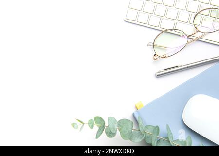Keyboard, computer mouse and notebook with pen on white office desk.  Directly above shot of office desk and stationery on white background Stock Photo