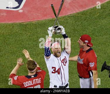 Washington Nationals' Bryce Harper (L) of the National League is awarded  the trophy by his father Ron Harper after winning the 2018 Home Run Derby  at Nationals Park in Washington, D.C. on