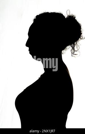 silhouette of young brunette woman in profile backlight Stock Photo