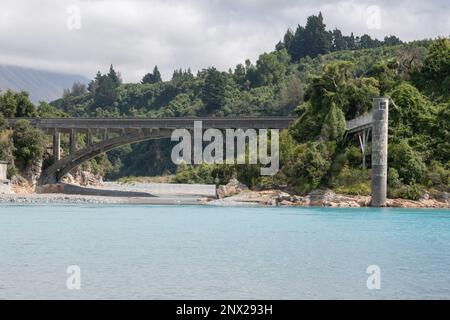 An old historic bridge over the vibrantly blue water of the Rakaia river in New Zealand. Stock Photo