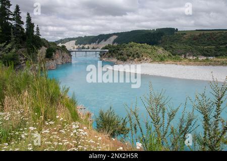 The Rakaia river gorge and the surrounding landscape, a historic bridge passes over the blue water consisting of glacial meltwater in New Zealand. Stock Photo