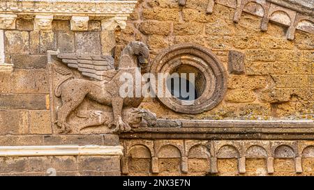 Decorative detail representing a winged griffin on the facade of the Basilica of San Pietro in Tuscania. Tuscania, Viterbo province, Lazio, Italy Stock Photo