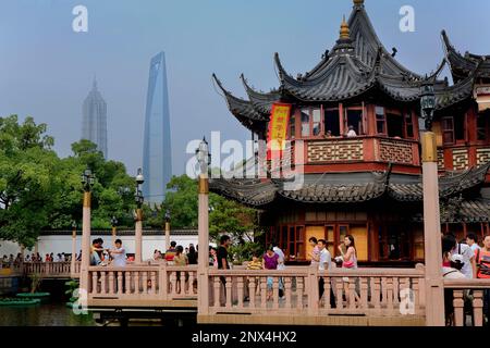 China.Shanghai: Yu Yuan Bazar. Zigzag bridge and Huxinting Tea House at right. Pudong Skyline in Background with  Jin Mao Building and Shanghai World Stock Photo