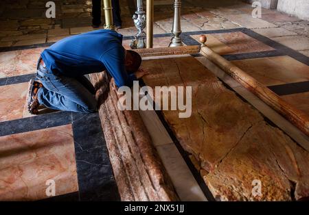 Man praying,Stone of Unction, Church of the Holy Sepulchre also called the Church of the Resurrection, Christian Quarter,Old City, Jerusalem, Israel. Stock Photo