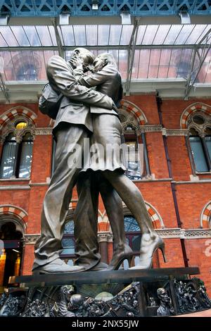 Vertical view of 'The Meeting Place' bronze statue of lovers couple in love loving embrace at St Pancras International railway station London UK Stock Photo