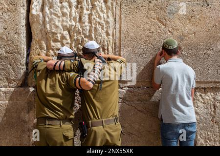 men's prayer area, soldiers and civilian man praying at the Western Wall, Wailing Wall, Jewish Quarter, Old City, Jerusalem, Israel. Stock Photo