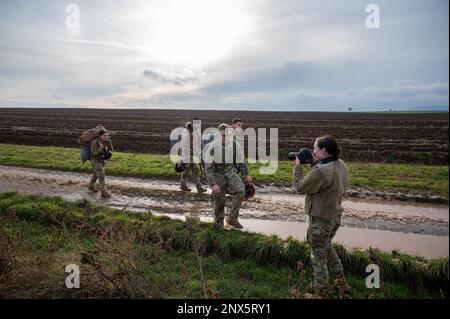 U.S. Air Force Airman 1st Class Kaitlyn Oiler, 86th Airlift Wing public affairs apprentice, right,  takes a photograph of Airmen from the 435th Security Forces Squadron, including her husband, Staff Sgt. Matthew Oiler, 435th Contingency Response Group team chief, after a static line jump at Alzey Drop Zone in Ober-Flörsheim, Germany, Jan. 20, 2023. Airman 1st Class Oiler said she was proud of her husband because he was successful on each jump during training and earned his wings. Stock Photo