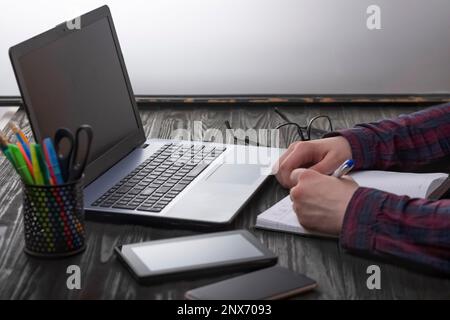 Young businessman or freelancer working with documents and with laptop and smartphone, remote office Stock Photo
