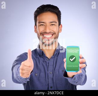 Asian man, phone and thumbs up in payment received ecommerce, transaction or internet banking success. Portrait of happy male showing smartphone Stock Photo