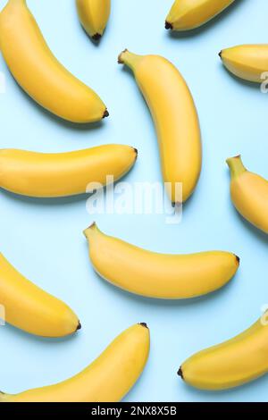 Sweet ripe baby bananas on turquoise background, flat lay Stock Photo