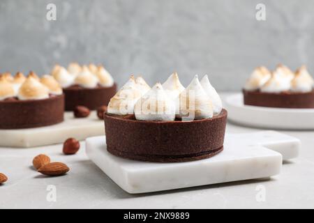 Delicious salted caramel chocolate tart with meringue on light grey table Stock Photo