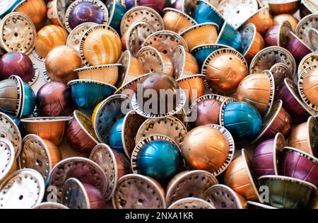 Dumped plastic and metal espresso coffee capsules environmental issue. Hundreds of used coffee pods Stock Photo