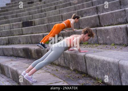 Two young caucasian women athletes performing incline push up exercise on a set of stairs Stock Photo Alamy