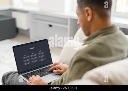 Lisbon, Portugal - March 01, 2023: African-American male student using laptop with opened webpage of chat gpt. Guy is using Chat gpt for researching, studying or creating content Stock Photo
