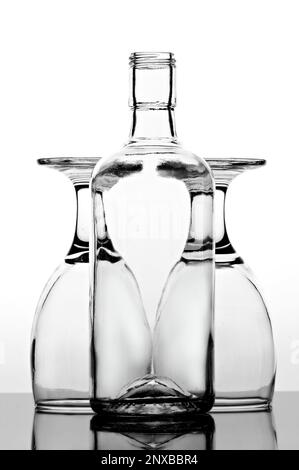 Close-up of an empty glass of bottle in front of two upside down glasses Stock Photo