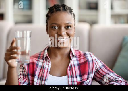 Pretty young african american woman holding glass of water Stock Photo