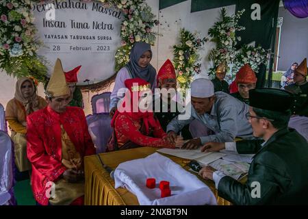 Bogor, Indonesia. 28th Feb, 2023. A visually impaired couple take part on a procession wedding during a mass marriage for visually impaired in Bogor, West Java, Indonesia on February 28, 2023. Twelve blind couples got married for free by a social foundation to help economically disadvantaged people with disabilities get legal. (Photo by Andi M Ridwan/INA Photo Agency/Sipa USA) Credit: Sipa USA/Alamy Live News Stock Photo