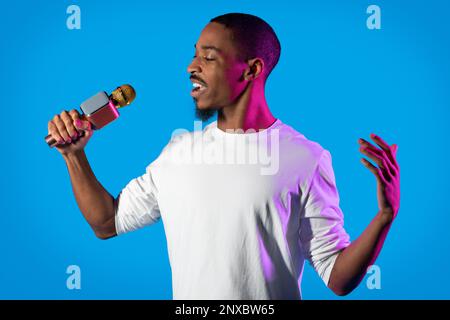 Emotional african american guy performing singing on blue Stock Photo