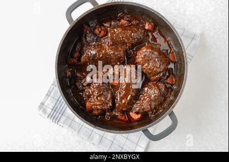 Beef roulades with gravy and roasted vegetables in a roasting pan before sieving. Cooking, making, preparation. Part of a series Stock Photo