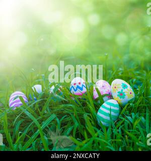 Colorful Easter eggs arranged on the grass with a bokeh background for customizable text. This festive image is perfect for Easter greetings or social Stock Photo