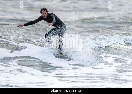 Florida surfer riding the nose of his surfboard on a small winter wave at Jacksonville Beach. (USA) Stock Photo