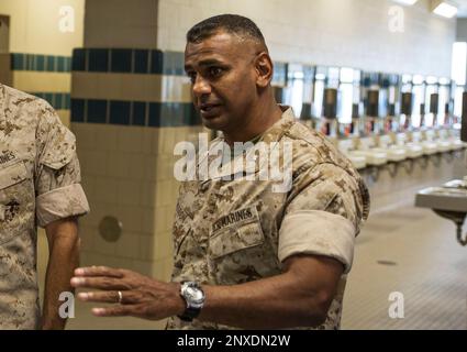 A Drill Instructor (DI) shows a recruit the proper way to aim and hold ...