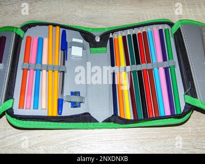 Pencil case with colored pencils, crayons, pen, eraser, sharpener. School concept Stock Photo