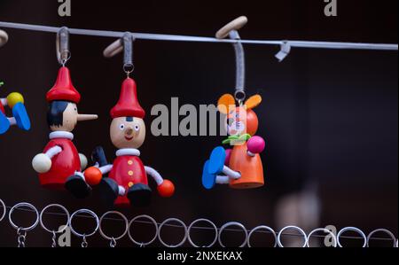 Wooden hand work, Wooden colorful smiley key rings hanging on wire with blur background. Selective focus. Stock Photo