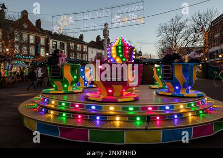 Carlisle Christmas Market and lights with snowman and teacup merry go round, snowflakes on buildings. Stock Photo