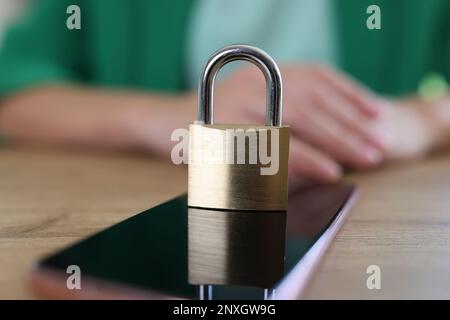 Closed metal padlock on modern smartphone, personal data protection Stock Photo