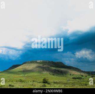 Beautifull view of tipical plane top hills north Uruguay. Green down part whith stone grey top. sunny blue sky and storm clouds in impactant pictture Stock Photo