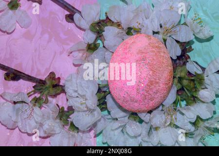 branch flowers underwater and pink eggs above, creative spring holiday design Stock Photo