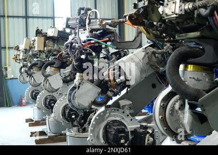 Robotic arm in futuristic assembly manufacturing factory, in factory shop floor. Stock Photo