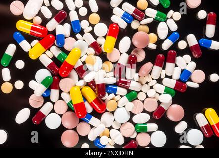several colored pills on a black background, top view Stock Photo