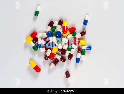 colored pills thrown on white background, top view Stock Photo