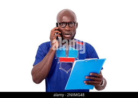 portrait of a surprised businessman talking on mobile phone while checking contract on clipboard. Stock Photo