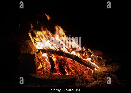 campfire at night with dark background and bed of hot coals Stock Photo