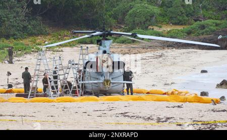 U.S. military personnel examine U.S. Marine Corps' UH-1Y helicopter after its emergency landing on a beach in Uruma, Japan's southern Okinawa islands, Sunday, Jan. 7, 2018. The helicopter made an emergency landing on the beach Saturday after indications that the main rotor was moving at too high a speed. No one was injured in the incident. (Shohei Seki/Kyodo News via AP)