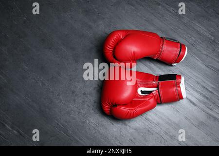 Pair of red boxing gloves on grey stone background, flat lay. Space for text Stock Photo