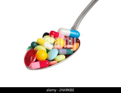Different colorful pills in spoon isolated on white Stock Photo
