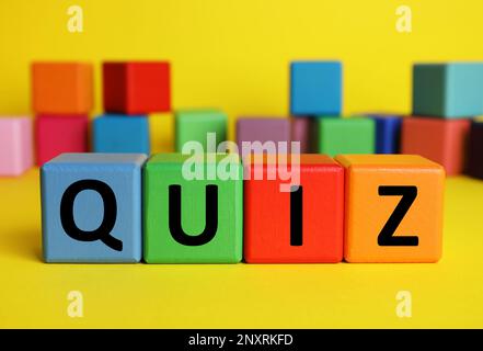 Colorful cubes with word Quiz on yellow background. Space for text Stock Photo