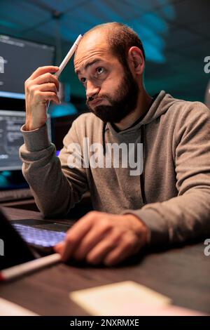Thoughtful developer brainstorming ideas to find source code and develop html script on terminal window. Thinking about solution to create cloud computing server interface, coding program. Stock Photo