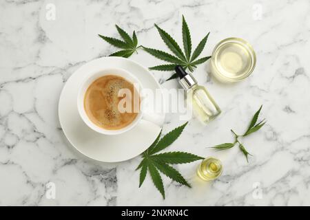 CBD oil, THC tincture, cup of coffee and hemp leaves on white marble table, flat lay Stock Photo