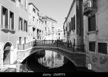 VENICE, ITALY - JUNE 13, 2019: City canal with old buildings and boats. Black and white tone Stock Photo