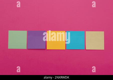 some heart-shaped sticky notes of different colors with a blank