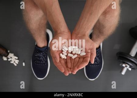 Man with handful of pills, top view. Doping concept Stock Photo