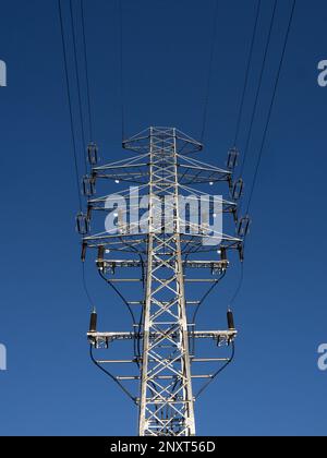 High voltage power pole on the background of blue sky. Stock Photo