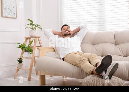 Handsome man relaxing on sofa at home Stock Photo