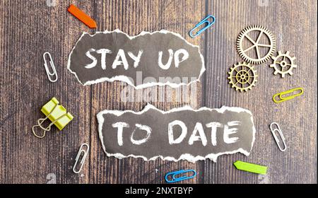 stay up to date. different stationery and text on notepad Stock Photo